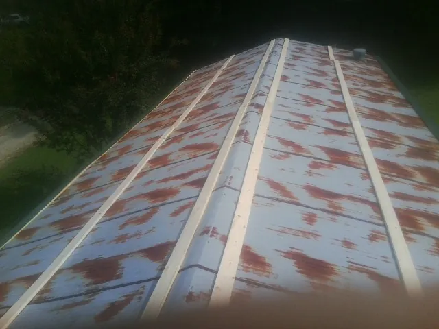 Rusted metal roof panels with new wood purlins before replacement — Storm Damage Roof Repair in Winter Garden by Roofing Brothers