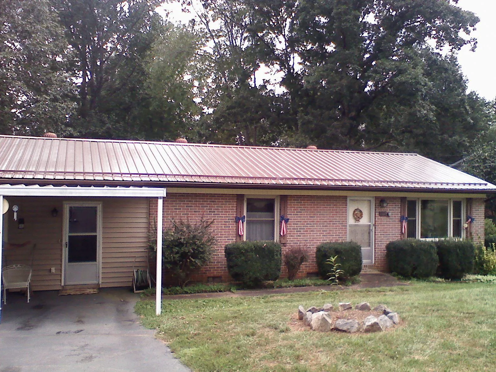 Bronze metal roof and carport on a brick ranch home — Roof Repair work by our crew in Winter Garden